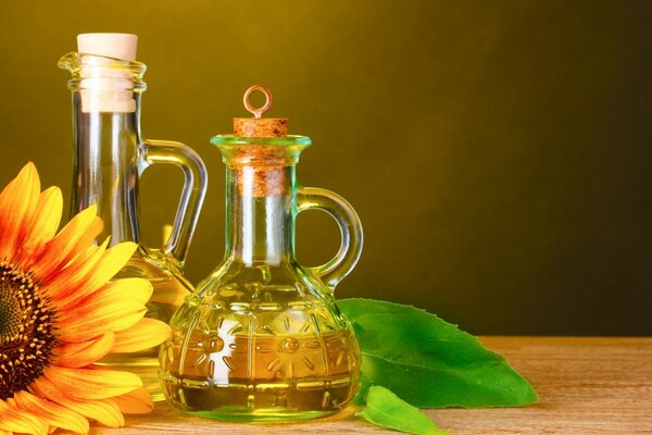 A glass bottle with sunflower oil stands on a wooden table