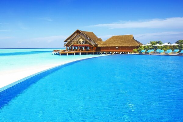 Casa en la playa junto al mar bajo el cielo azul