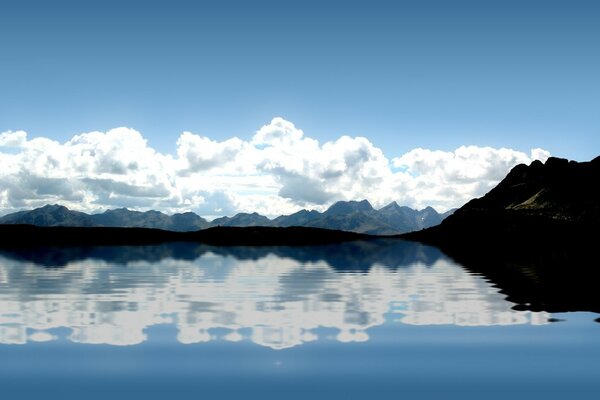 Sur le lac se trouve tranquillement l eau reflétant les nuages et les montagnes