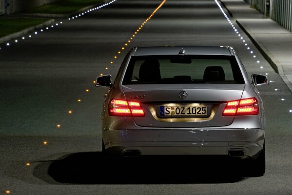 En la carretera, un Mercedes negro con luces de freno encendidas