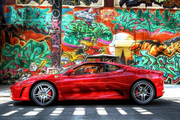 Auto rossa su sfondo muro con graffiti