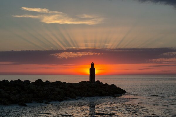 Landschaft mit Sonnenuntergang und Leuchtturm