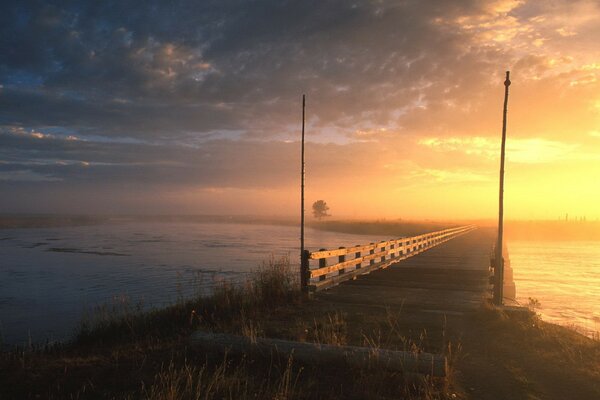 The bridge on the river looks mysterious in the fog