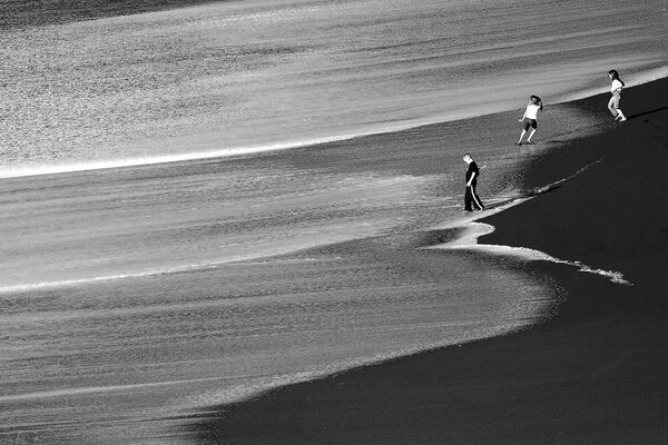 Les enfants rattrapent les vagues sur le sable