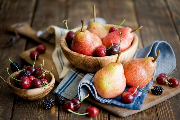 Frutta e bacche si trovano appetitosamente in ciotole di legno