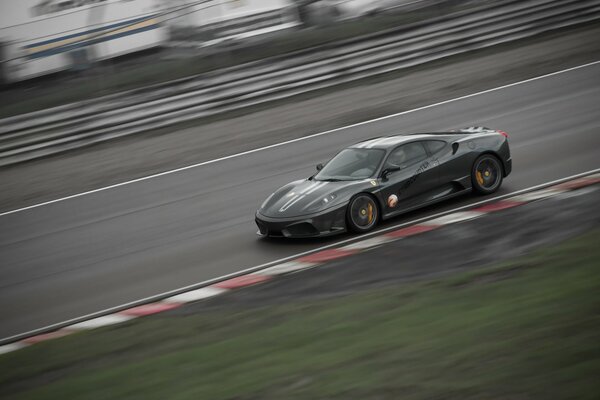 Foto ein schwarzer Ferrari f430 auf einer Autospur