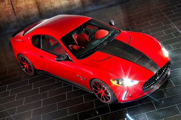 Red Maserati granturismo with a black stripe on the hood