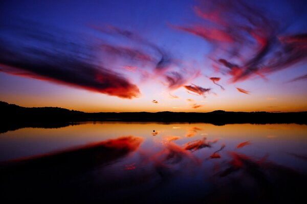 Die violetten Wolken spiegeln sich im Wasser wider