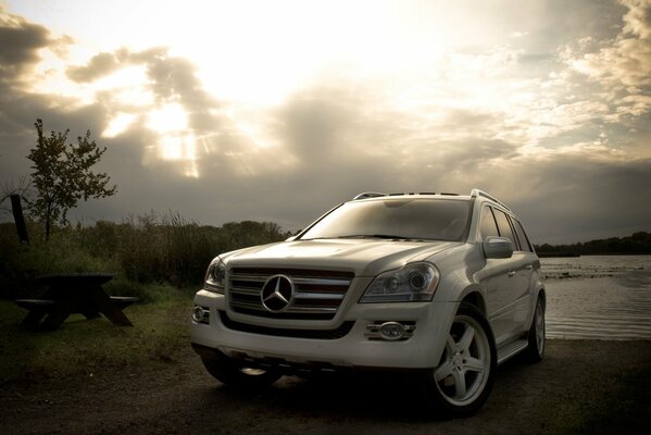 Mercedes blanco cerca del río nublado