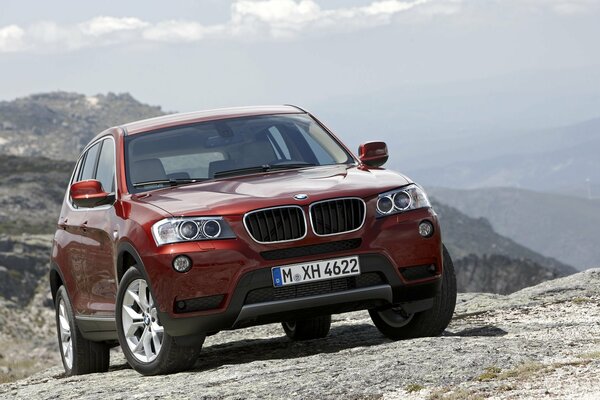 BMW rouge sur les rochers avec une belle vue