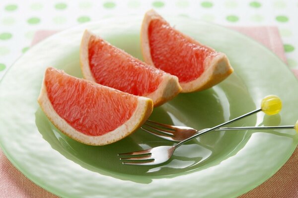 Fruta pomelo en un plato verde