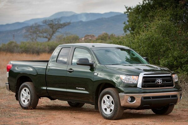 Toyota pickup truck stands against the background of mountains