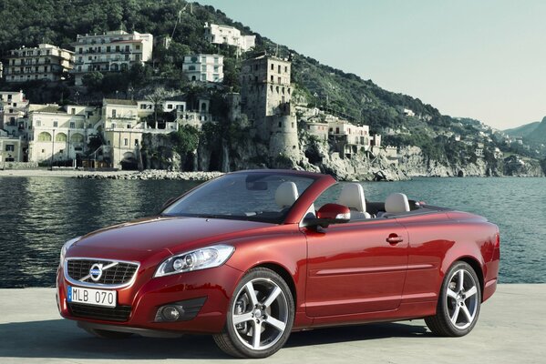 Auto rossa Volvo C70 convertibile sullo sfondo della città