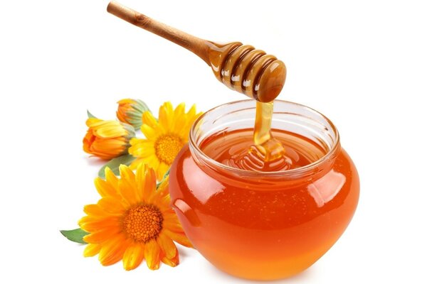 Flower honey with a spoon on a white background