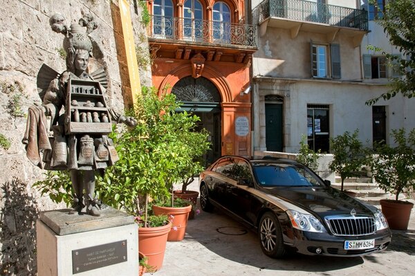 Maybach negro cerca del monumento al perfumista en Francia