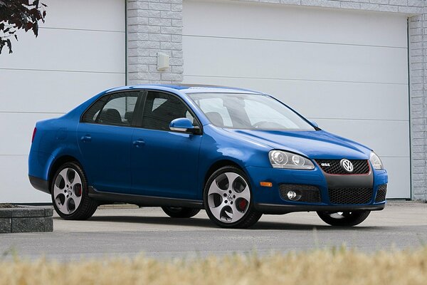 Voiture bleue avec étriers rouges sur fond de garages