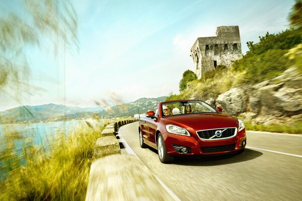 Volvo car on the background of the castle and the ocean