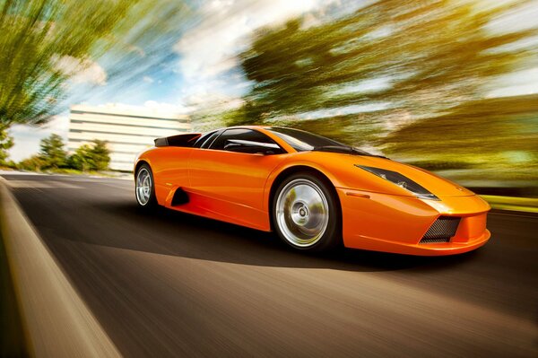 A bright orange lamborghini is racing down the road