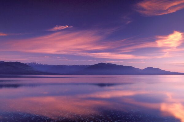 Reflection of mountain peaks and clouds in the lake