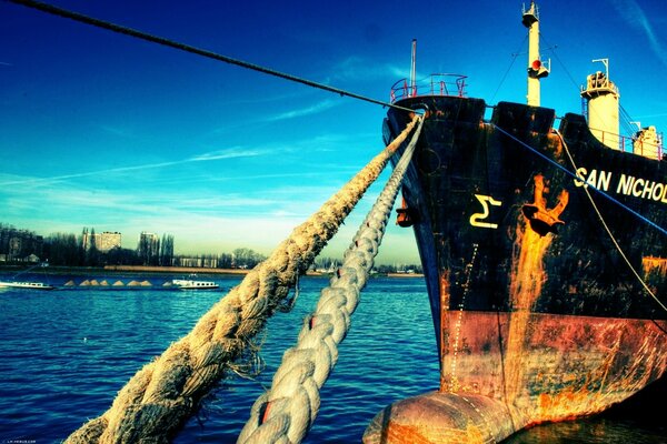 Barco negro atrapa con cuerdas al muelle