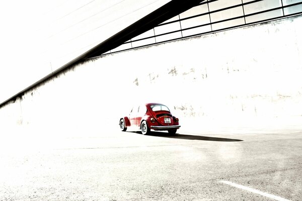 Title red car on the background of a beetle building