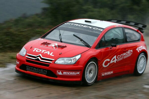 Citroen C4 rojo en la carretera mojada