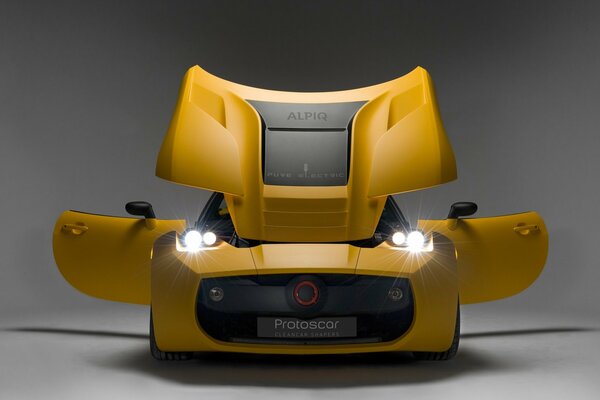 A powerful, yellow sports car with headlights on on a gray background. Beautiful