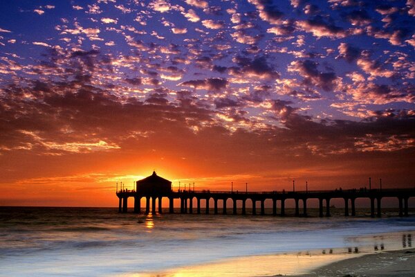 Die Brücke steht vor dem Hintergrund des Sonnenuntergangs am Meer