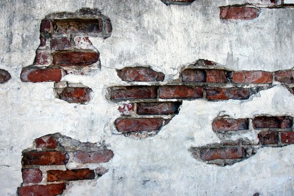 Alte Mauer aus rotem Backstein mit Putz bedeckt