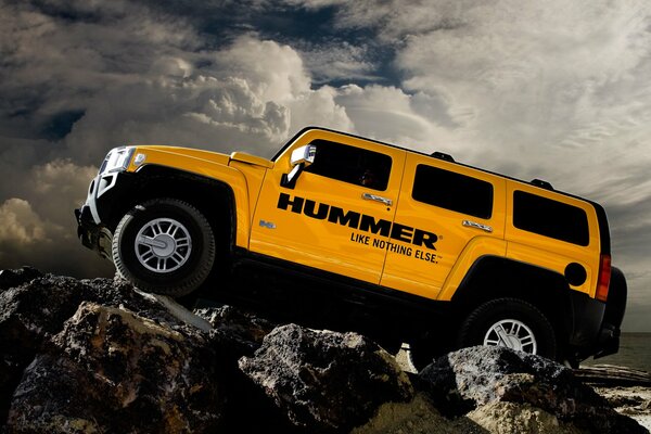 Hummer giallo sulle rocce su uno sfondo di nuvole