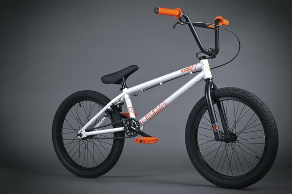 White with orange handles bmx bike on gray background