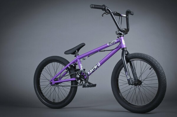 Bicicletta bmx viola su sfondo grigio