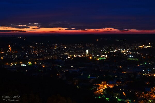 Sunset over a night city with orange clouds