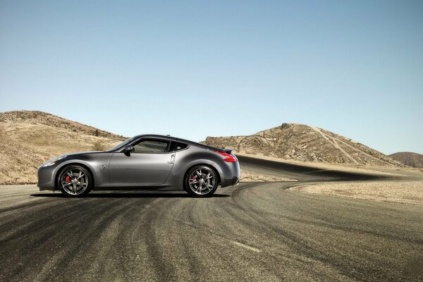 A gray Nissan car is on the road