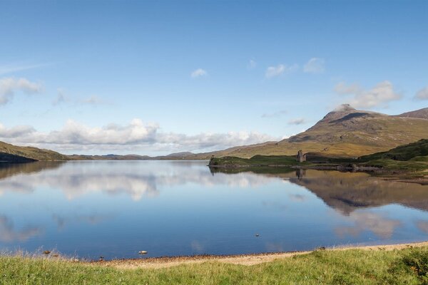 Scottish lake between the hills. Clouds are reflected