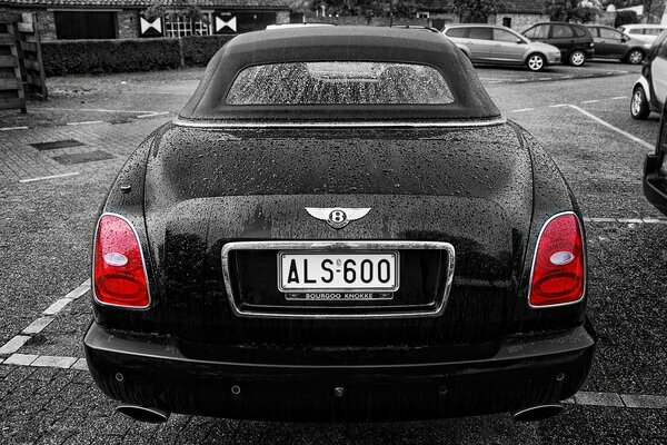 Lieber Bentley mit roten Scheinwerfern auf dem Parkplatz in s/w