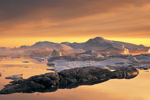 Rocks under a blanket of snow among the ice