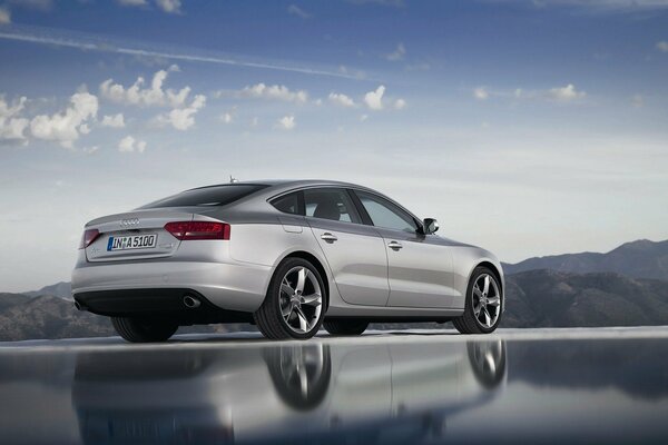 Shiny silver audi on a background of variable clouds