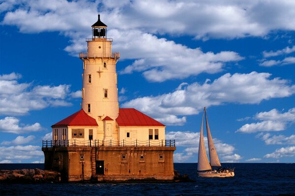 Phare et yacht dans la mer bleue