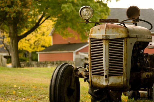 An old rusting tractor on the background of autumn