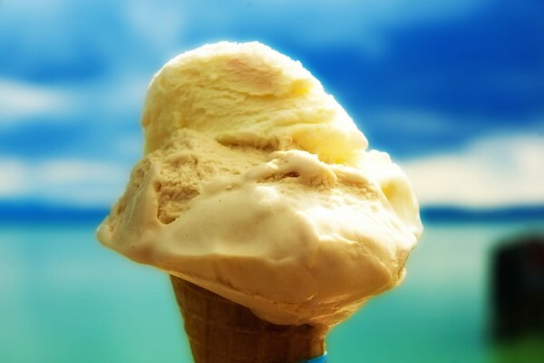 Cono gelato giallo sullo sfondo del mare