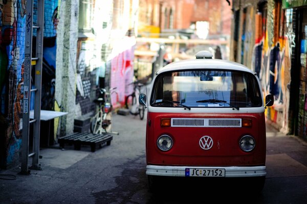 Una furgoneta Volkswagen roja en una calle estrecha de la ciudad