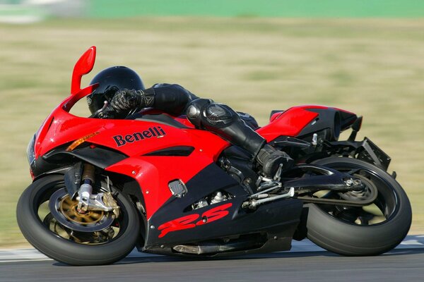 Motociclista en un deportivo rojo en una curva