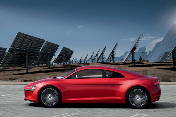 There is a red car with solar panels on the road