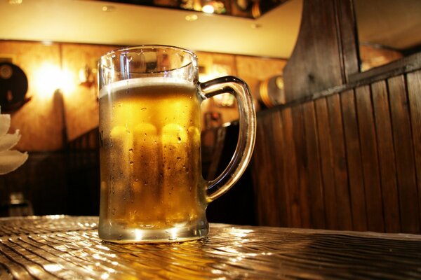 Gran taza de cerveza fría en la mesa del Bar