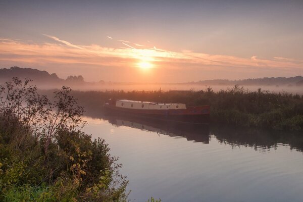 Sonnenuntergang am Ufer. Barkas bei Sonnenuntergang