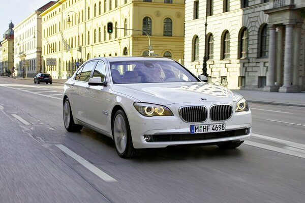 A picture of a bmw white car in the city