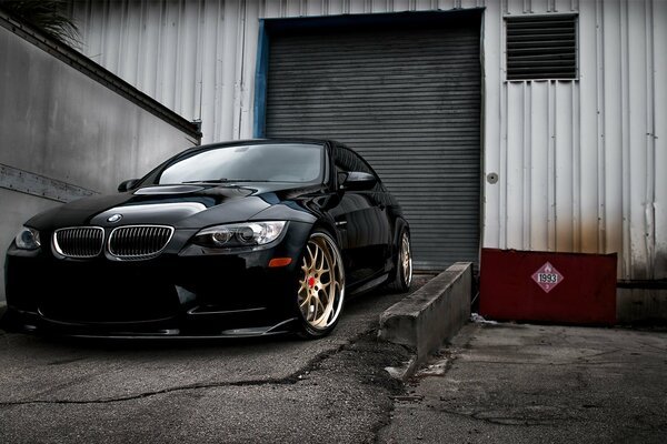 Black BMW e92 on the background of the garage