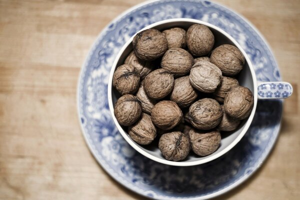 Taza llena de nueces en la mesa