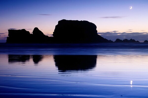 Reflection of rocks and the moon in the water